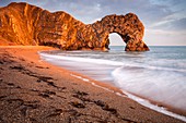 The natural sea arch at Durdle Door on Dorset's Jurassic Coast, bathed in late evening light in mid April.