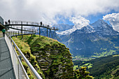 Several people stand on cliff walk with a view of Fiescherhorn and Eiger, Tissot Cliff Walk, First, Grindelwald, Bernese Oberland, UNESCO World Natural Heritage Swiss Alps Jungfrau-Aletsch, Bernese Alps, Bern, Switzerland
