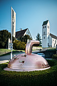 Beer kettle in front of Berg brewery, St Ulrich chapel in the background, Ehingen, Danube, Alb-Danube district, Baden-Württemberg, Germany