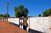 Gambia; Central River Region; Kuntaur; an der Hauptstraße; Mauer mit Eingangstor zu einem Privatgrundstück