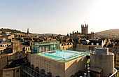 View of exterior roof-top pool set against the scenery of old turrets and buildgs, Horizontal. Bath. United Kingdom