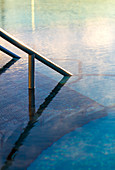 Detailaufnahme eines Geländers, das ins Wasser im Außenpool mit Dampf führt. Bath, Vereinigtes Königreich