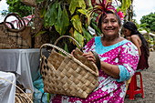 Portrait of a Tahitian woman with a bag traditionally woven from pandanus fibers at a cultural festival, Papeete, Tahiti, Windward Islands, French Polynesia, South Pacific