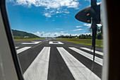View out of window on engine of Air Tahiti ATR 72-600 airplane on runway 30 at Moorea Airport (MOZ), Windward Islands, French Polynesia, South Pacific