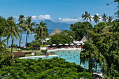Coconut trees and swimming pool at Tahiti Ia Ora Beach Resort (managed by Sofitel), near Papeete, Tahiti, Windward Islands, French Polynesia, South Pacific