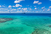 Luftaufnahme von türkisfarbenen Wasser in der Lagune mit Passagierfrachter Aranui 5 (Aranui Cruises) vor Anker in der Ferne, Insel Avatoru, Rangiroa-Atoll, Tuamotu-Inseln, Französisch-Polynesien, Südpazifik