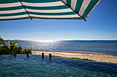 Menschen entspannen sich im Infinity Pool im Malamala Island Beach Club, Mala Mala Island, Mamanuca Group, Fidschi-Inseln, Südpazifik