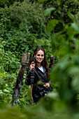 Junge Frau mit Wanderstock während eines Trekking Ausflug zur Sabyinyo Gruppe von Gorillas, Volcanoes National Park, Northern Province, Ruanda, Afrika