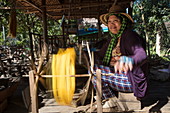 Woman weaves silk on loom in a silk factory, Oknha Tey Island, Mekong River, near Phnom Penh, Cambodia, Asia