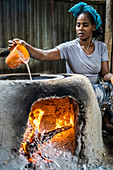 Woman making injera bread on traditional oven, Berhale, Afar Region, Ethiopia, Africa