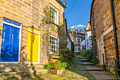 View of houses in The Opening and narrow cobbled alley in Old Bay, Robin Hood's Bay, North Yorkshire, England, United Kingdom, Europe