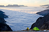 Man and tent above the clouds, Trentino-Alto Adige, South Tyrol in Bolzano district, Alta Pusteria, Hochpustertal,Sexten Dolomites, Italy