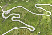 Vertikale Drohnen-Luftaufnahme der kurvenreichen Straße des Pordoi-Passes während eines Sommertages, Fassa-Tal, Dolomiti, Gemeinde Canazei, Provinz Trento, Trentino-Südtirol, Italien, Europa