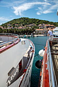 Spiegelung der Namensschrift von Kreuzfahrtschiff auf einem anderen Schiff mit Blick auf Stadt, Vis, Vis, Split-Dalmatien, Kroatien, Europa