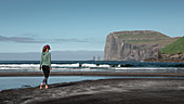 Frau am Sandstrand im Dorf Tjørnuvík auf Streymoy auf Färöer Inseln bei Tag\n