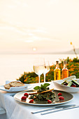 Food at a restaurant with a view over Pefkos Beach beach at sunset, Pefkos, Rhodes, Dodecanese, Greek Islands, Greece, Europe