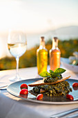 Spanikopita with white wine at sunset at a restaurant in Pefkos, Rhodes, Dodecanese, Greek Islands, Greece, Europe