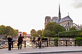 France, Paris, a saxophonist on the bridge of the Archbishop's and Notre Dame de Paris