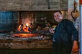 Freundlicher Koch bereitet köstliches Asado Fleisch auf Holzkohlengrill in der Finca Piedra zu, San José de Mayo, Colonia Department, Uruguay, Südamerika