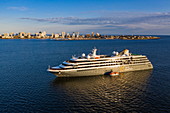 Aerial view of expedition cruise ship World Explorer (Nicko Cruises) with city skyline behind at sunset, Punta del Este, Maldonado Department, Uruguay, South America