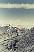 Frau mit Kamera steht auf einem Berg beim Lünersee, Vorarlberg, Österreich, Europa
