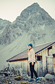 Frau steht an der Totalphütte im Rätikon über dem Lünersee, Vorarlberg, Österreich, Europa