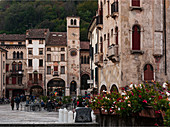 People in  Piazza Flaminio in the Serravalle district in Vittorio Veneto, in the background the Civic Tower and the Community Palace. Veneto region. Italy