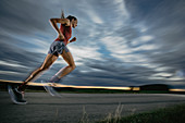Woman runner runs on road in sunset, sport, forest