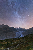 Glowing stars and Milky Way in the night sky over Aletsch Glacier, Bernese Alps, Valais canton, Switzerland, Europe
