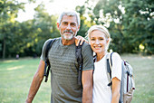 Portrait of smiling mature couple standing in forest