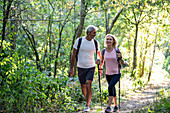 Smiling mature couple hiking together in forest