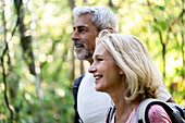 Smiling mature couple looking away in forest