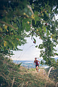 Junge Frau läuft bei Abendstimmung am Falkenstein, Allgäu, Bayern, Deutschland