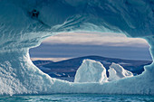 Ein Loch in einem Eisberg im De Dodes Fjord (Fjord der Toten), Baffin Bay, Grönland, Polarregionen