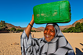 Frau, die einen Wasserbehälter auf ihrem Kopf, Oase von Timia, Luftberge, Niger, Afrika trägt
