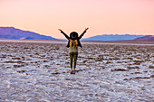 Model posing for the camera at sunset over the salt flats of the Mesquite Dunes, California, United States of America, North America
