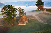 Ländliche Landschaft mit traditionellen strohgedeckten Holzhäusern in Dumesti, Apuseni-Gebirge, Rumänien, Europa