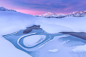 Verrückte Form in einem gefrorenen Alpensee bei Sonnenaufgang mit Blick auf Berg Disgrazia, Valmalenco, Valtellina, Lombardei, Italien, Europa