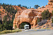 Wohnmobil, das aus dem roten Felsentunnel auf Utah State Route 12, Red Canyon, Dixie National Forest, Utah, Vereinigte Staaten von Amerika, Nordamerika hervorgeht