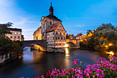 Germany, Bavaria, Bamberg, Town buildings with arch bridge illuminated at dusk