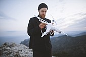 Italy,Liguria,La Spezia,Man at mountain top holding drone