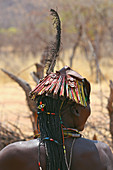Angola; Provinz Cunene; Frau aus der Volksgruppe der Mucohona; auffällige Haartracht mit Perlen, Muscheln und einer langen Feder; dazu fein eingearbeitete bunte Stäbe, aus Konservendosen gefertigt