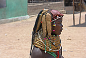 Angola; Provinz Huila; kleines Dorf in der Umgebung von Chibia; junge Muhila Frau mit typischem Hals- und Kopfschmuck; Haarbüschel mit Lehm umhüllt und fixiert; massiver Halsreif aus geflochtenem Stroh und Erde