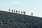 Hikers walking around Gran Crater rim, Vulcano Island, Aeolian Islands, Sicily, Italy