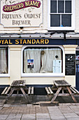 Weathered tables out side a traditional English pub in Old Town, Hastings, East Sussex UK.