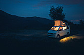 VW Bus beleuchtet, in der blauen Stunde, VW T6 California, Bulli, Berge in der Abenddämmerung, Blaue Stunde, Ligurien, Italien