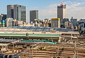 View of Tokyo Central Station with Shinkansen trains and the skyline of Marunouchi, Tokyo, Japan