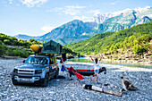 Albanien, Südeuropa, junge Frau morgens vor Geländewagen mit Dachzelt, Aufwachen, Fluss, Vjosa