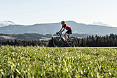 Racing cyclists on the Bichlpass; in the background the Teisenberg, Neukirchen, Bavaria, Germany