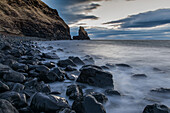 Abenddämmerung, glänzende Steine bei Ebbe am Strand der Talisker Bay, Isle of Skye, Schottland, UK